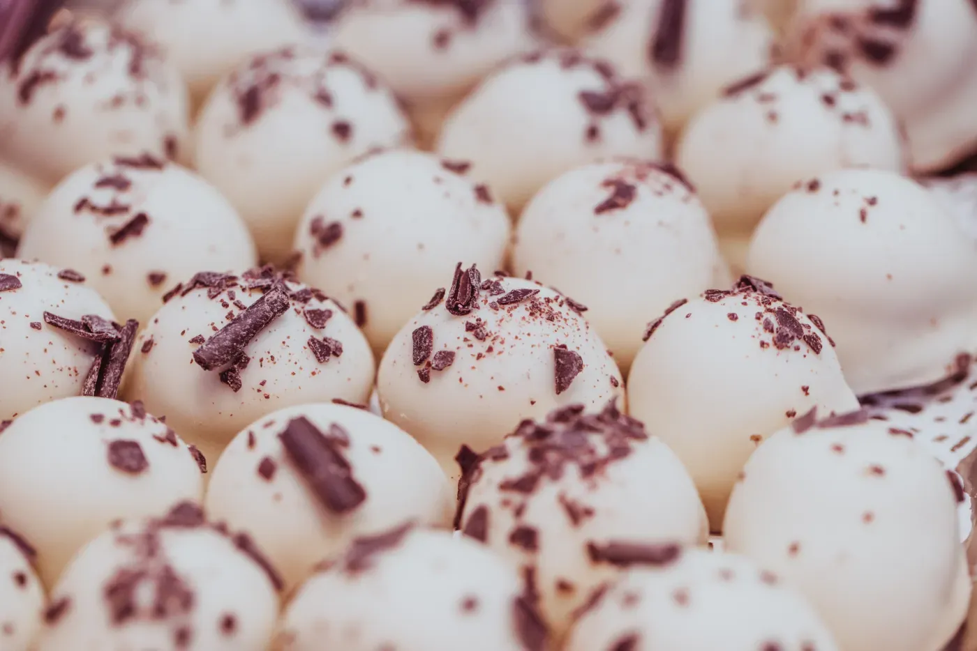 Weiße Zimt-und-Zucker-Pralinen mit dunkler Schokoladenraspel bestreut