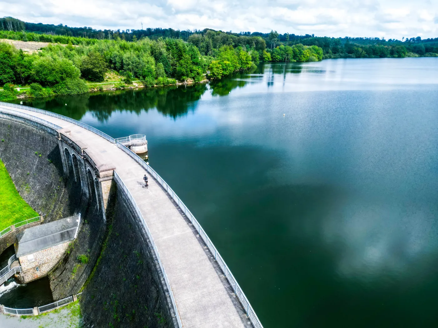 Luftaufnahme einer Talsperre mit Fahrradweg auf der Mauerkrone