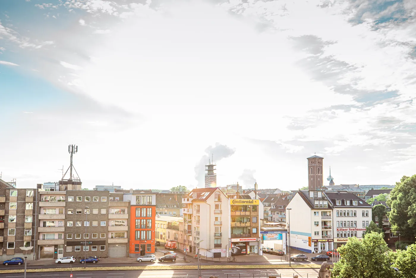 Kölner Skyline mit Kirchturm und Hausfassaden im goldenen Licht