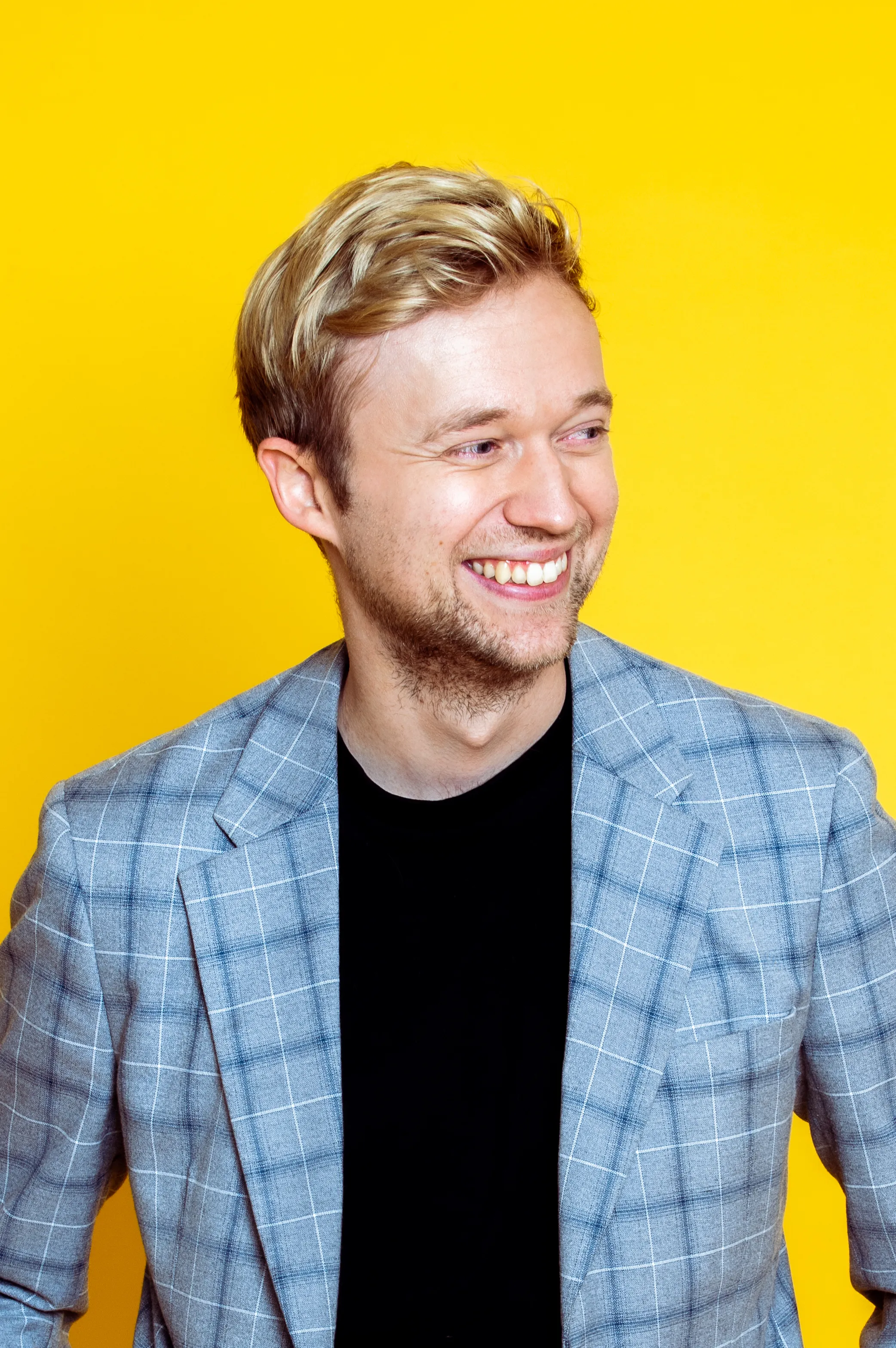 Marc Weide, Kunde aus dem Bereich Bühnenprogramme, im Studioportrait vor gelbem Hintergrund